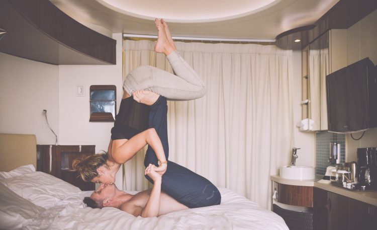 Man And Woman Kissing Whilst Playing On A Hotel Bed